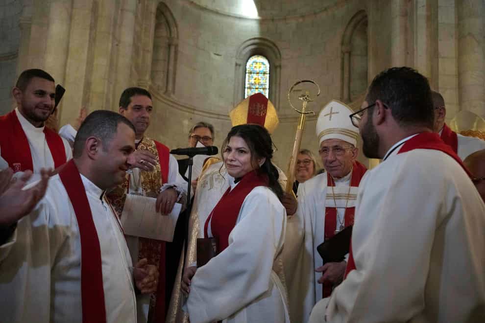 Sally Azar, centre, is applauded by clergy after being ordained in the Old City of Jerusalem (Maya Alleruzzo/AP)