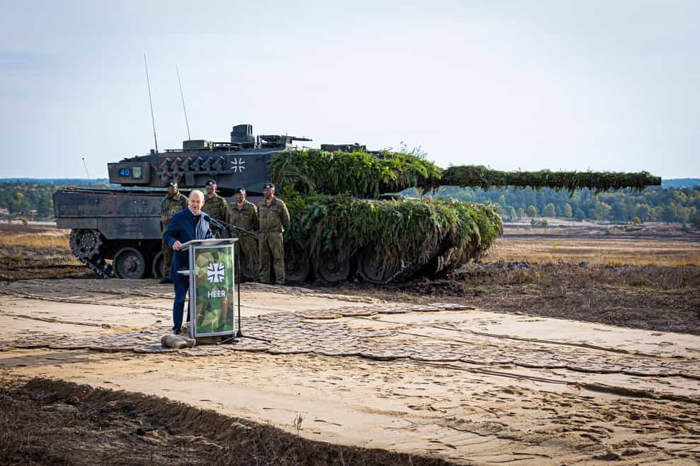German Chancellor Olaf Scholz speaks to soldiers in front of a Leopard 2 main battle tank after the Army’s training and instruction exercise in Ostenholz, Germany (dpa via AP)