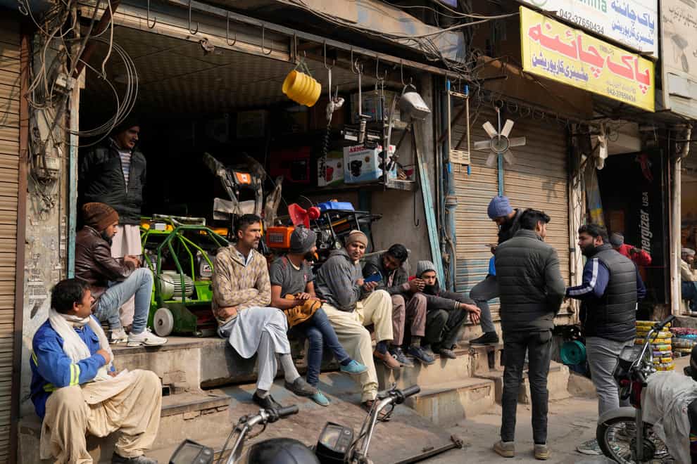 Shopkeepers and workers wait for electric power at a market (AP)