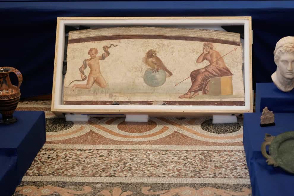 A Pompeiian-style fresco from Herculaneum titled Young Hercules and the snake on display among other archaeological artefacts stolen from Italy and sold in the US by international art traffickers, during a press conference in Rome (Andrew Medichini/AP)