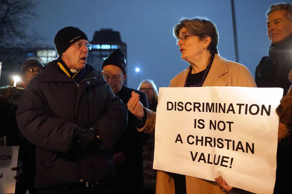 The Archbishop of Canterbury Justin Welby, left, speaks with Jayne Ozanne, right, and other LGBT+ campaigners and their allies outside Lambeth Palace, south London, ahead of a reception for parliamentarians to demand an end to the discrimination against LGBT+ people in the Church of England (Yui Mok/PA)