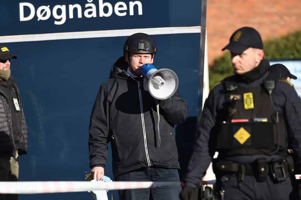 Far-right activist Rasmus Paludan speaks on a megaphone in front of a mosque in the Noerrebro area of Copenhagen, Denmark on Friday Jan. 27, 2023 where planned to burn the Quran. Turkey has summoned the Danish ambassador over reports that an anti-Islam activist will be allowed to burn the Quran on Friday during a series of protests in Copenhagen. (Olafur Steinar Gestsson/Ritzau Scanpix via AP)