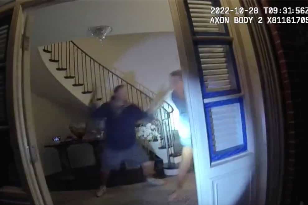 In this image taken from San Francisco Police Department body-camera video, Paul Pelosi, right, the husband of former U.S. House Speaker Nancy Pelosi, fights for control of a hammer with his assailant during a brutal attack in the couple’s San Francisco home on Oct. 28, 2022. The body-camera footage shows the suspect David DePape wrest the tool from the 82-year-old Pelosi and lunge toward him the hammer over his head. The blow to Pelosi occurs out of view and the officers — one of them cursing — rush into the house and jump on DePape. (San Francisco Police Department via AP)