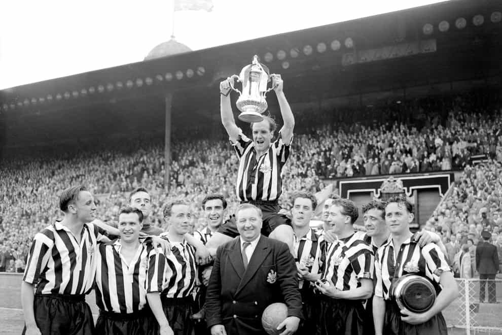 Newcastle captain Jimmy Scoular lifts the 1955 FA Cup aloft after a 3-1 victory over Manchester City (PA)