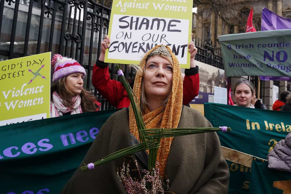 Lisamarie Johnson (centre), holding a traditional St. Brigid’s Cross made from rushes, attends a St Brigid’s Day rally outside Leinster House, Dublin, calling on the Government to take action in addressing violence against women in Ireland. The rally was held to coincide with St Brigid�s Day, with speakers asking that women be protected in the spirit of the Celtic goddess and Christian saint Brigid, who is associated with healing. Picture date: Wednesday February 1, 2023.