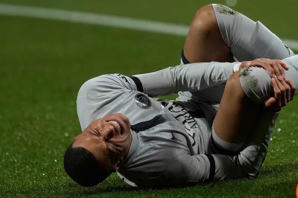 Injured PSG’s Kylian Mbappe grimaces in pain during the French League One soccer match between Montpellier and Paris Saint-Germain at the State La Mosson stadium in Montpellier, France, Wednesday, Feb. 1, 2023. (AP Photo/Thibault Camus)