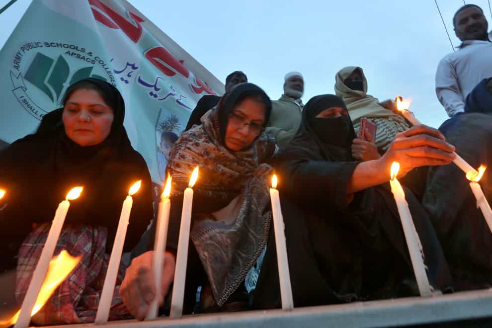 Women light candles during a prayer ceremony for victims of Monday’s suicide bombing inside a mosque in Peshawar, Pakistan (Muhammad Sajjad/AP)
