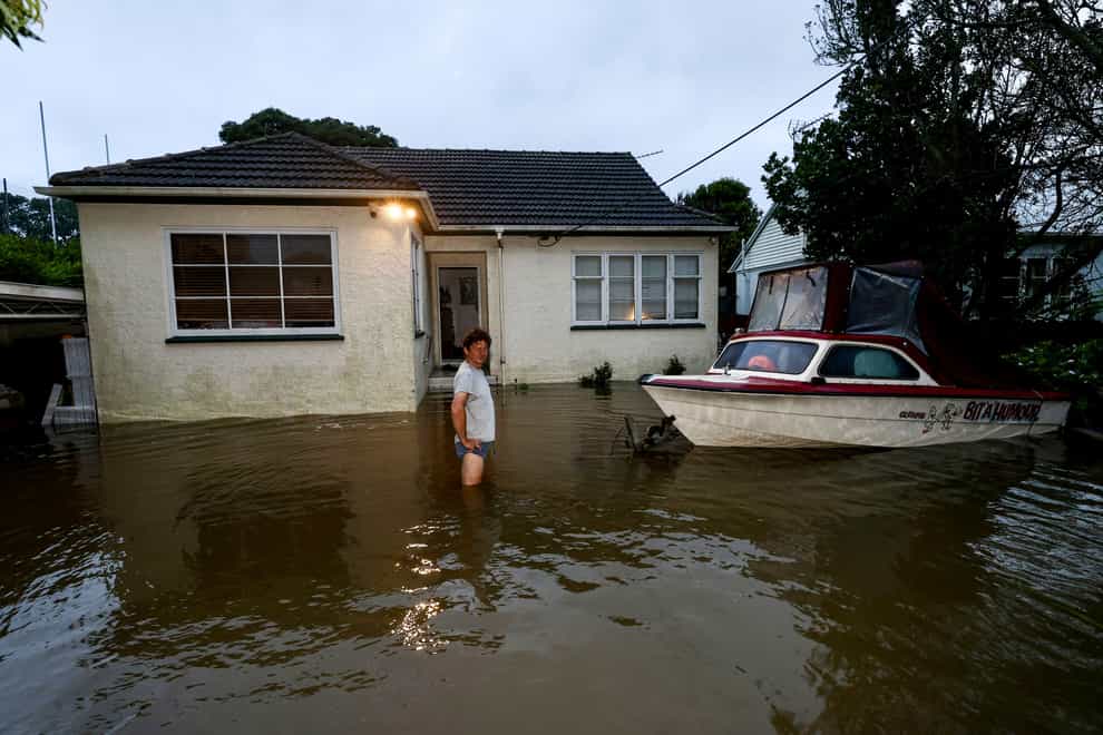 Slavko Snjegota stands in knee-deep water outside his house in Auckland (Brett Phibbs/New Zealand Herald via AP)