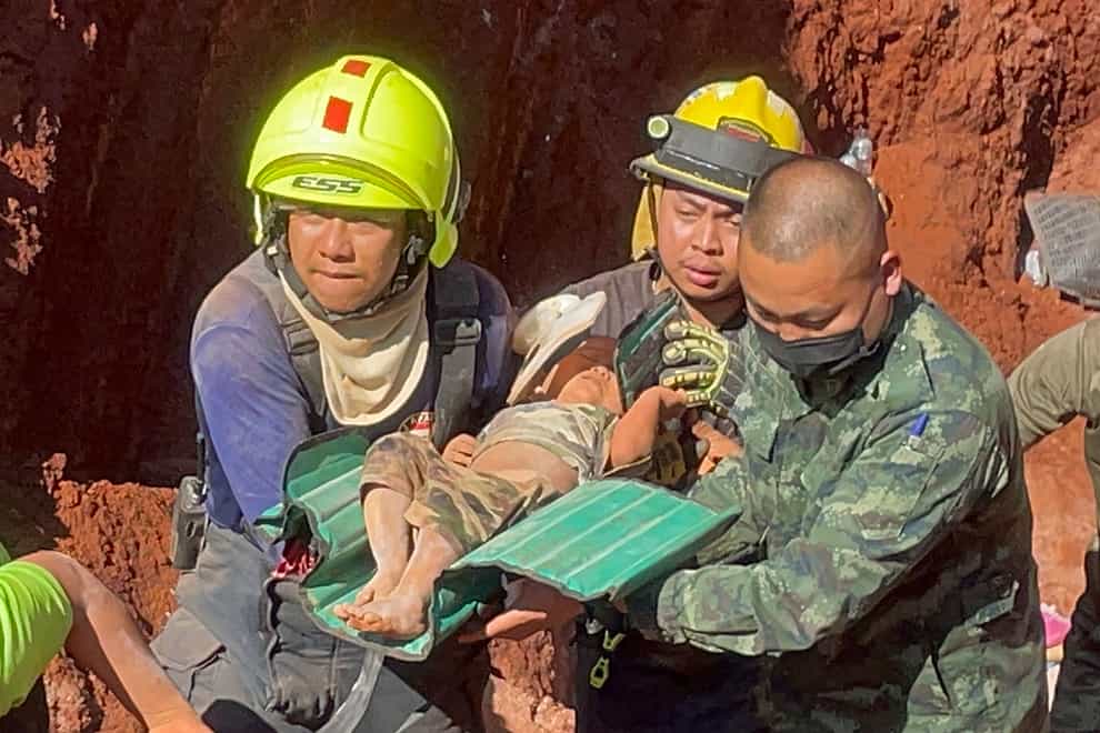 Rescue workers and soldiers carry the youngster from the dry well in the northern Thailand province of Tak (AP Photo/Chiravuth Rungjamratratsami)