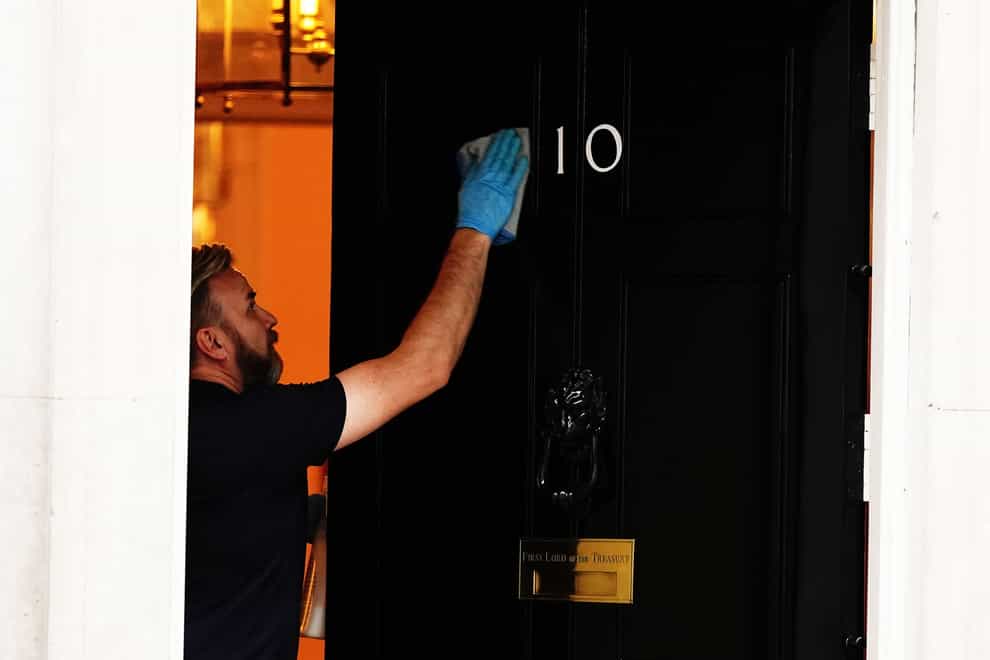 A person cleans the front door of 10 Downing Street, London. But department organisation is not simply a matter of changing a few signs (Aaron Chown/PA)