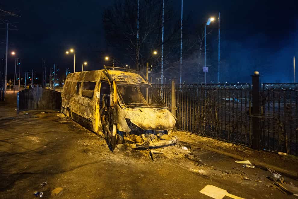 A burnt-out police van after a demonstration outside the Suites Hotel in Knowsley, Merseyside (Peter Powell/PA)