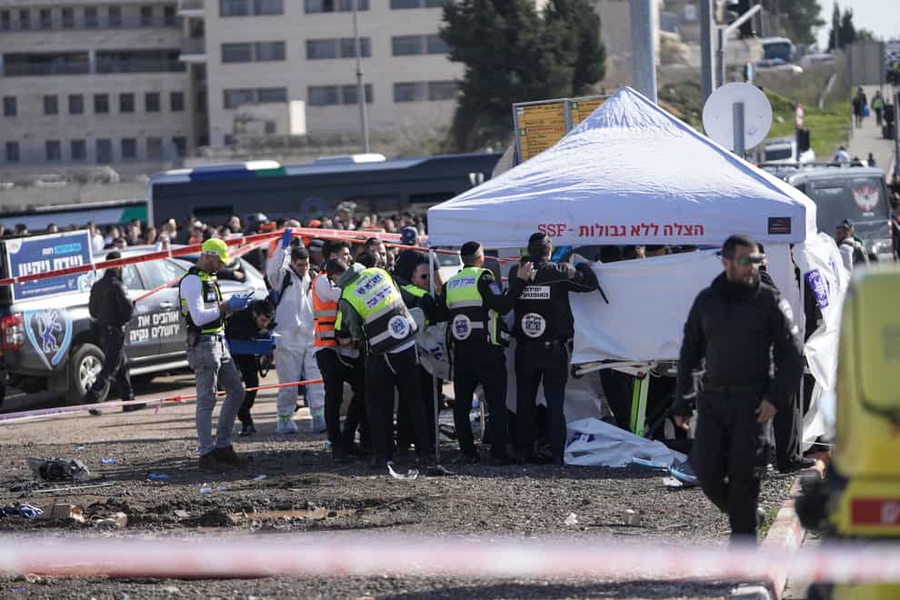 Members of Zaka Rescue and Recovery team work at the site of a car-ramming attack at a bus stop in Ramot, a Jewish settlement in east Jerusalem (Mahmoud Illean/AP)