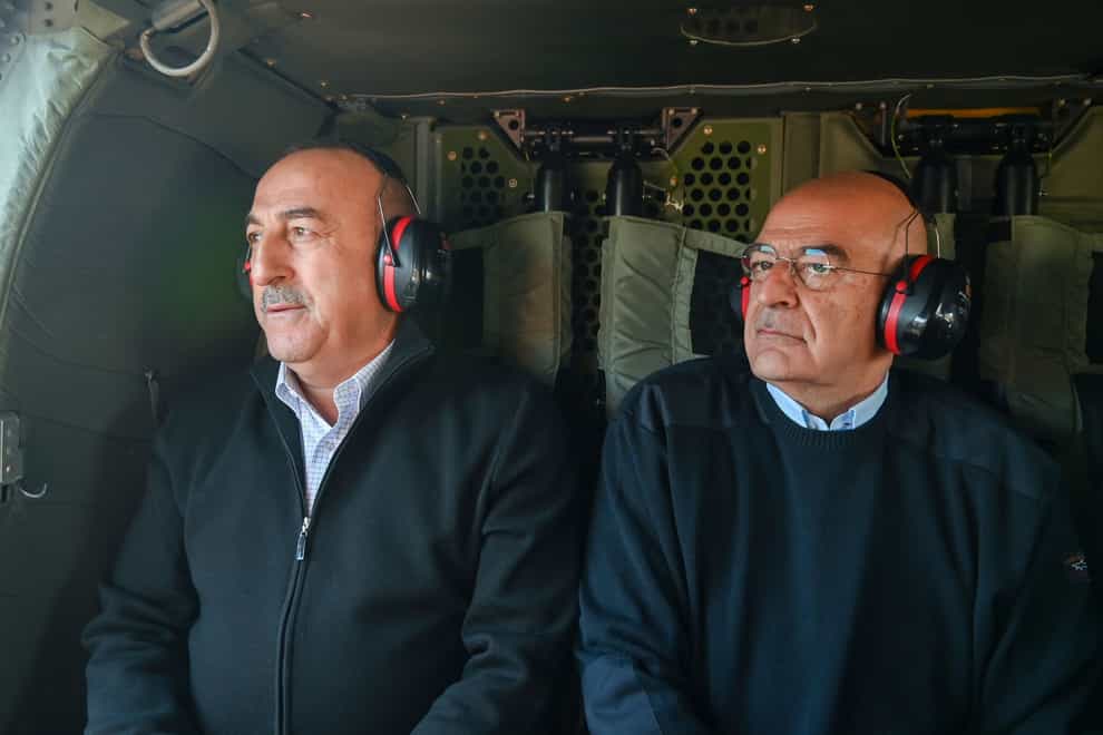 Greece’s foreign minister Nikos Dendias, right, accompanied by his Turkish counterpart, Mevlut Cavusoglu flies over the earthquake-stricken areas of Turkey (Greek Foreign Ministry via AP)