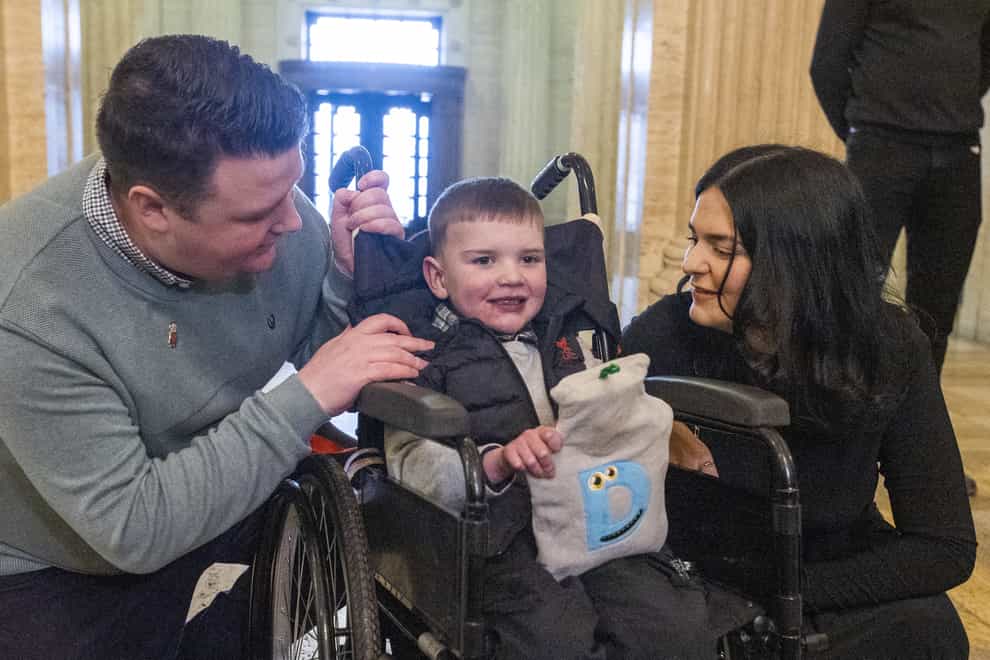 Six-year-old Daithi Mac Gabhann and his parents, father Mairtin Mac Gabhann (left) and mother Seph Ni Mheallain (right), at Parliament Buildings at Stormont, ahead of a recalled sitting of the Assembly focused on a stalled organ donation law. The law introducing an opt-out donation system in Northern Ireland has been named after Daithi, who is awaiting a heart transplant. Picture date: Tuesday February 14, 2023.