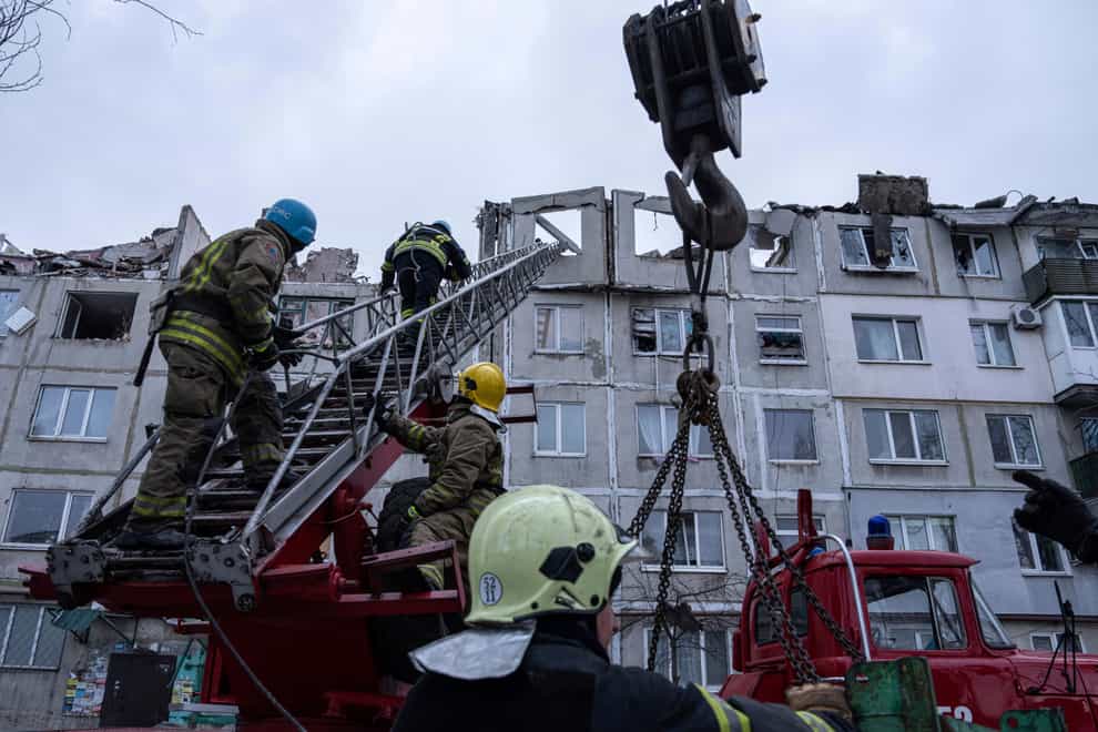 Rescue workers climb by ladder as they clear the rubble of a residential building which was destroyed by a Russian rocket in Pokrovsk (AP Photo/Evgeniy Maloletka)