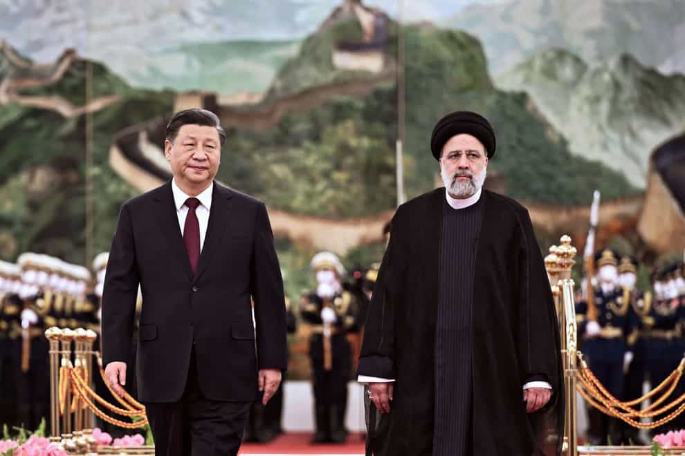 Iranian president Ebrahim Raisi, right, walks with Chinese president Xi Jinping as part of a trip to Beijing (Yan Yan/Xinhua via AP)