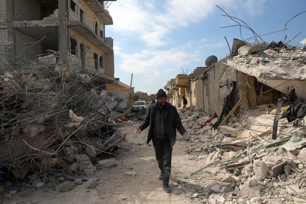 A man walks past collapsed buildings following a devastating earthquake in the town of Jinderis, Aleppo province, Syria (AP Photo/Ghaith Alsayed)