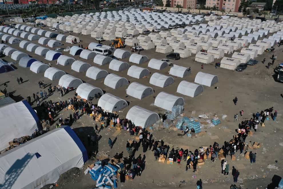 People who lost their houses line up to receive aid supplies at a makeshift camp in Iskenderun (Hussein Malla/AP)
