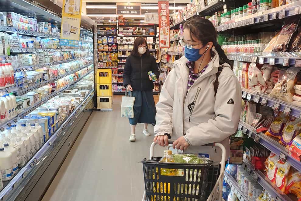 People wear face masks as they shop at a supermarket in Taipei, Taiwan (Chiang Ying-ying/AP)