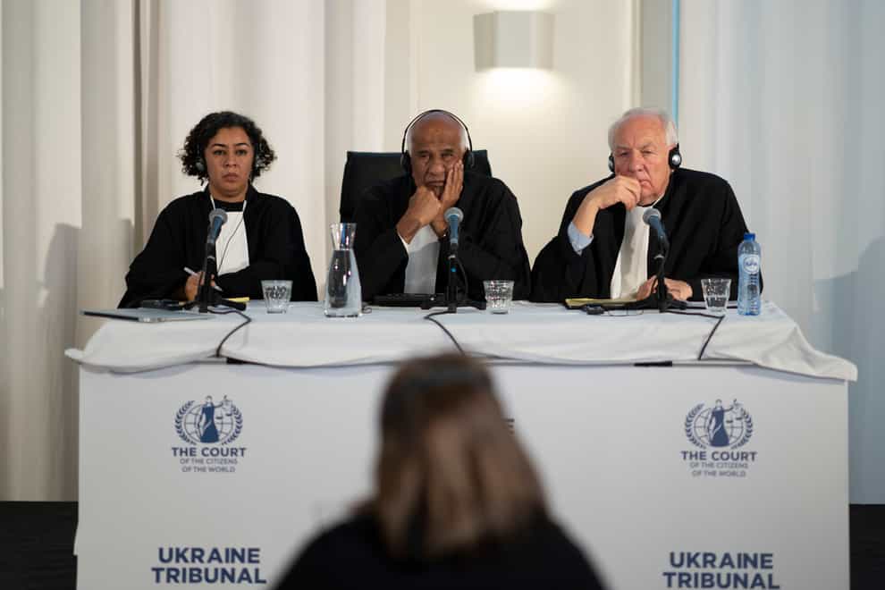 Judges Priya Pillai, left, Zak Yacoob, centre, and Stephen Rapp listen to the first witness of the ‘people’s tribunal’, where prosecutors symbolically put Russian President Vladimir Putin on trial for the crime of aggression in Ukraine in The Hague, Netherlands (Peter Dejong/AP)