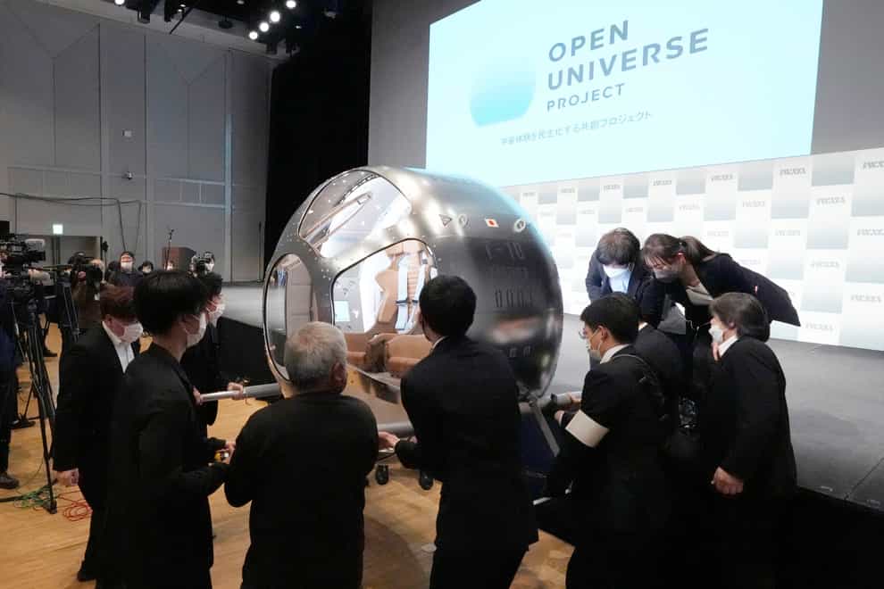 Staffers carry a two-seater cabin that a startup company says is capable of rising to an altitude of 15 miles, which is roughly the middle of the stratosphere (Eugene Hoshiko/AP)