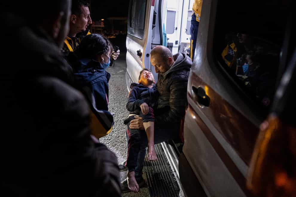 A boy is taken to an ambulance after being injured in the latest earthquake in Hatay, Turkey, Monday, Feb. 20, 2023. A new 6.4 magnitude earthquake on Monday struck parts of Turkey and Syria that were laid waste two weeks ago by a massive quake that killed around 45,000 people. Officials said more buildings collapsed, trapping occupants, and several people were injured in both countries. (Ugur Yildirim/DIA via AP)