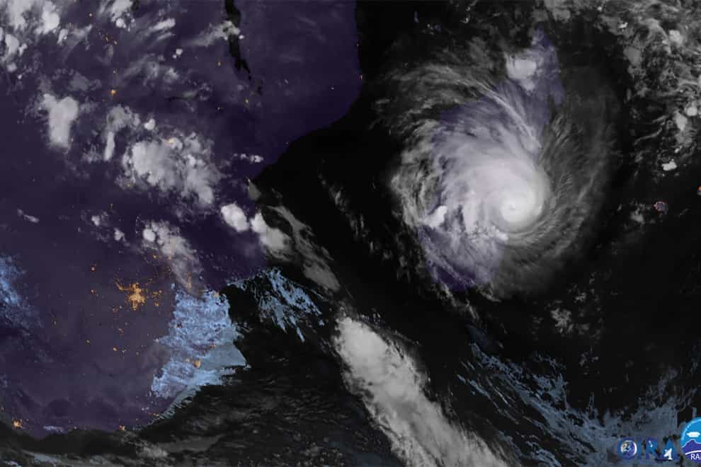 This image from Meteosat-9 satellite shows Tropical Cyclone Freddy, right, and Madagascar on Tuesday, Feb. 21, 2023. Schools, businesses and public transportation shut down before Freddy made landfall Tuesday evening, battering the island with strong winds and rain. (NOAA via AP)