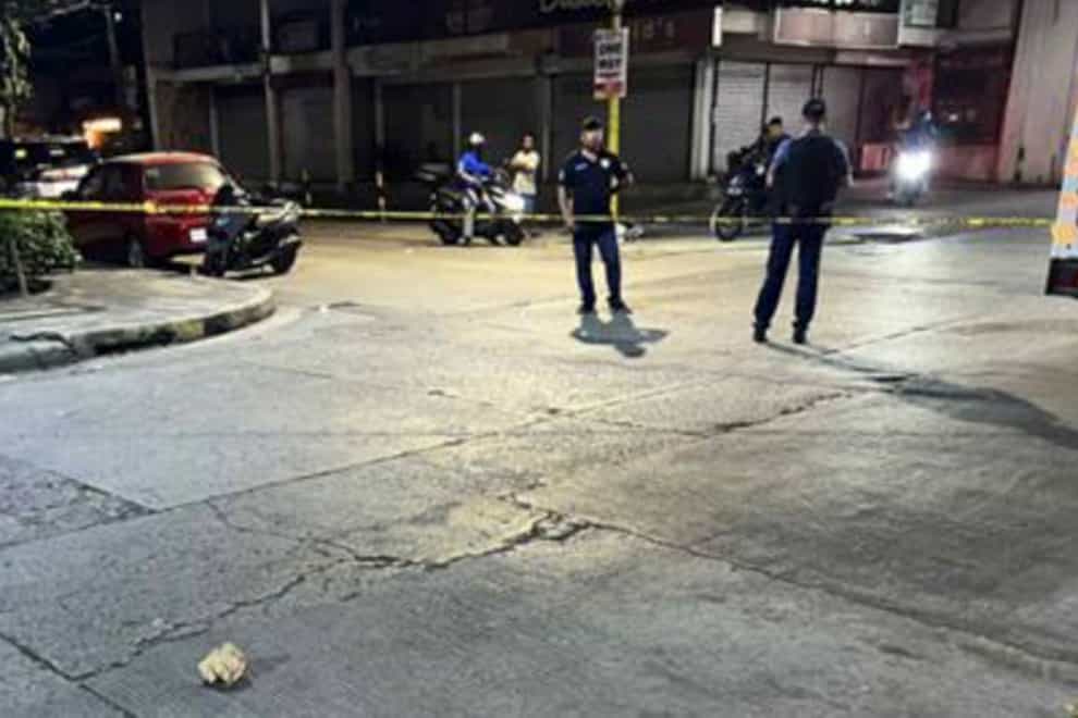 Investigators at the site where New Zealander Nicholas Peter Stacey was shot by robbers in Makati, Philippines (Public Information Office, National Capital Region Police Office/AP)