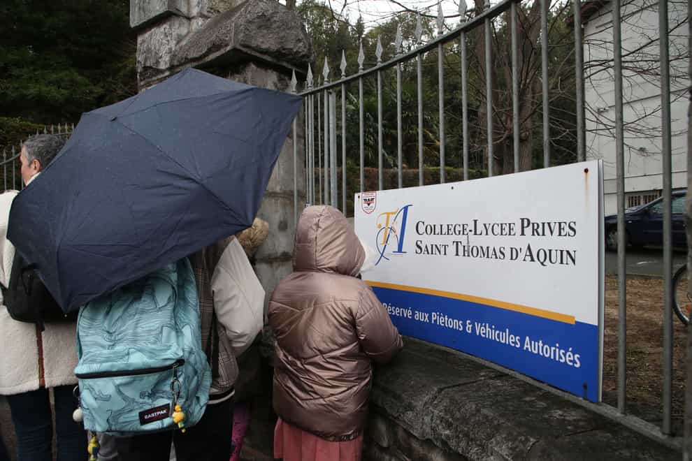 A child looks through the entrance of a private Catholic school after a teacher was stabbed to death (Bob Edme/AP)