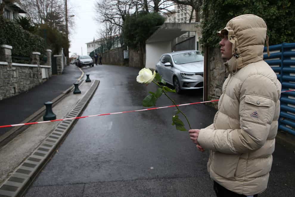 A youth holds a white rose at the entrance of a private Catholic school after a teacher of Spanish was stabbed to death (AP Photo/Bob Edme)