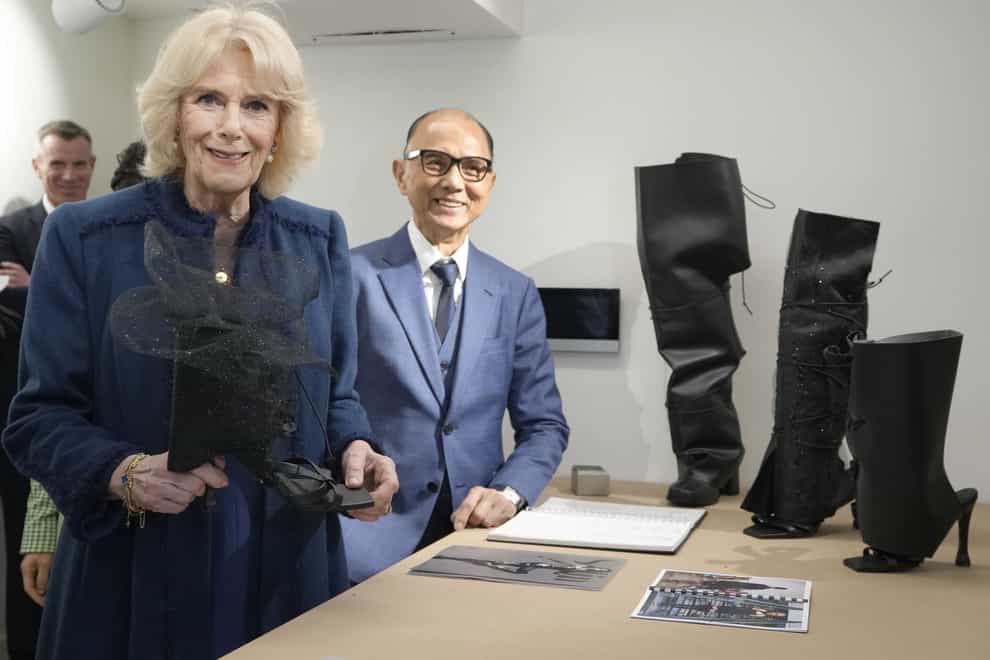 The Queen Consort holds an item of footwear made from sustainable cacti leather during a visit to the JCA London Fashion Academy in Brentford (Kirsty Wigglesworth/PA)