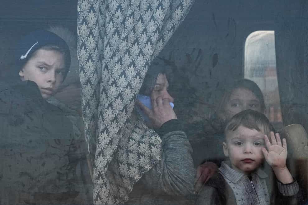 Internally displaced people look out from a bus at a refugee centre in Zaporizhia, Ukraine, on March 25, 2022 (Evgeniy Maloletka/AP/PA)