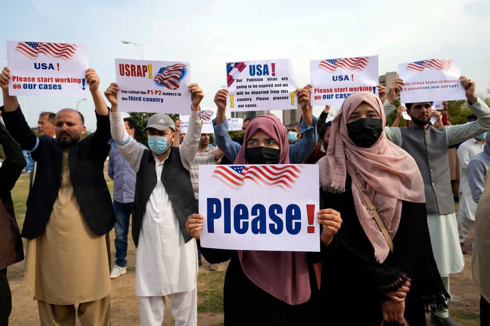 Afghan refugees hold placards during a protest in Islamabad, Pakistan (Rahmat Gul/AP)