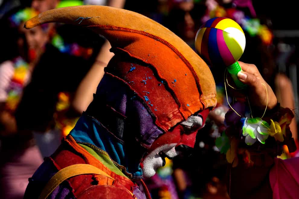 A man wearing carnival costume takes part in a traditional carnival parade in the southeast small town of Paralimni, Cyprus (Petros Karadjias/PA)
