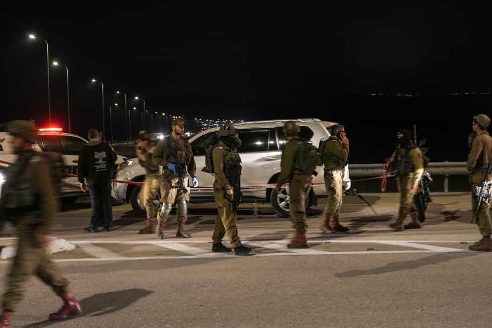 Israeli security forces examine the scene of a shooting attack near the West Bank city of Jericho (Mahmoud Illean/AP)