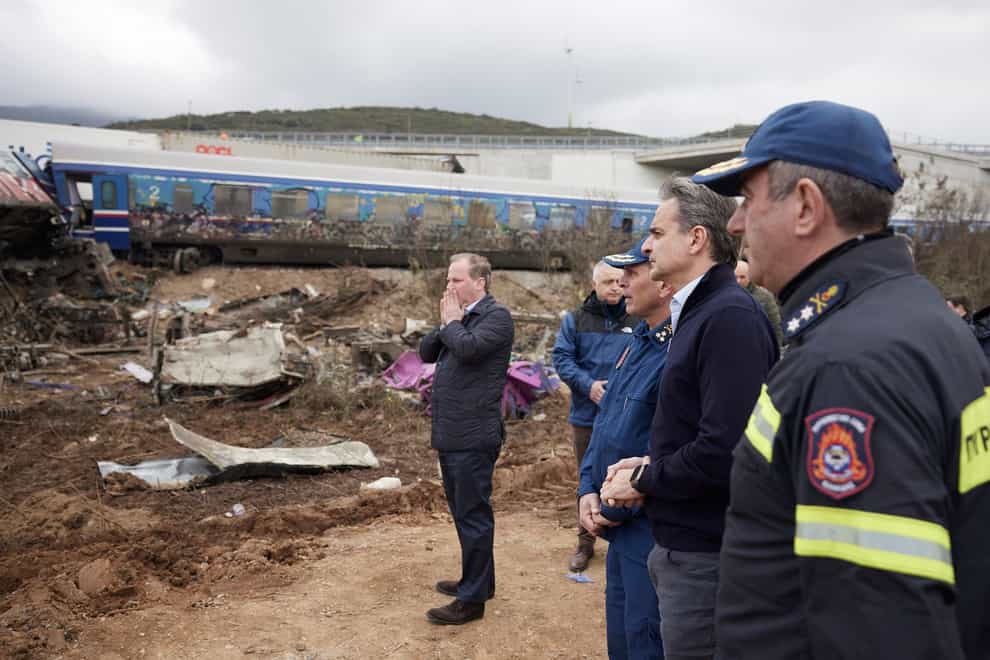 Greece’s Prime Minister Kyriakos Mitsotakis, second right, accompanied by transport minister Kostas Karamanlis, left, holding his face, looks the debris of trains after a collision in Tempe, about 376 kilometres (235 miles) north of Athens, near Larissa city, Greece, Wednesday, March 1, 2023 (Dimitris Papamitsos/Greek Prime Minister’s Office via AP/PA)