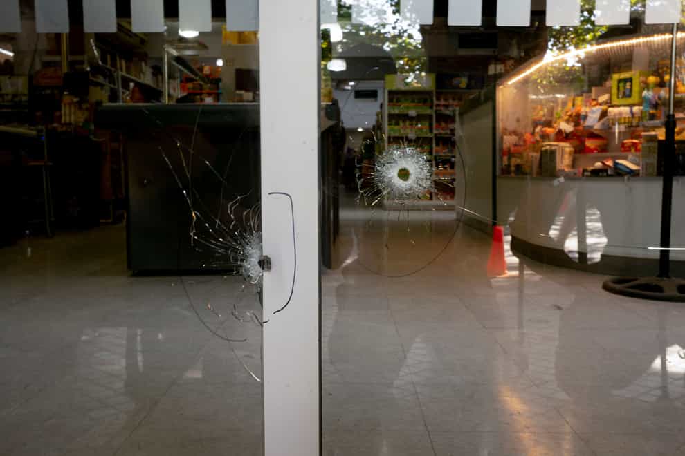Bullets holes in the window of the Unico supermarket (Sebastian Lopez Brach/AP)