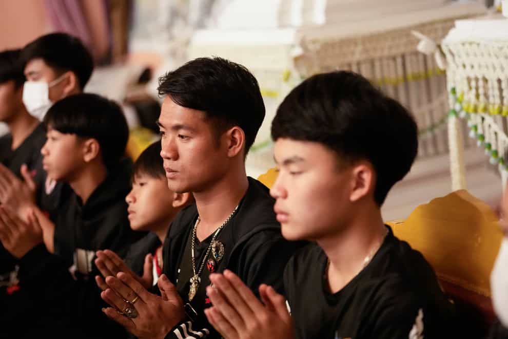 Former football coach Ekkapol Chanthawong, second right, prays during the funeral ceremony (Sakchai Lalit/AP)
