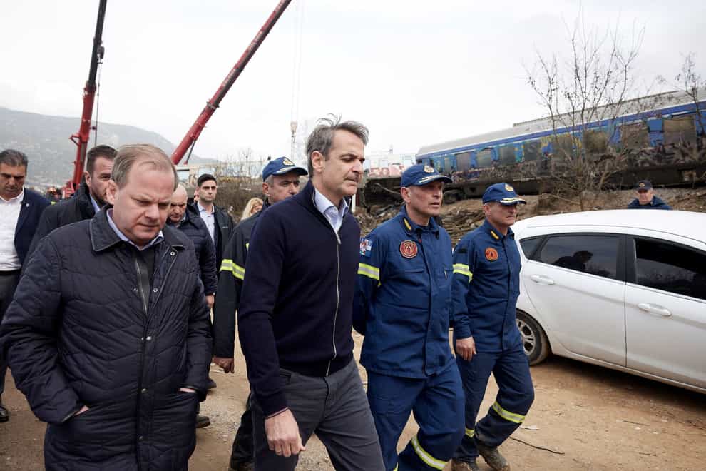 Greece’s Prime Minister Kyriakos Mitsotakis, second left, visits the location of the train collision (Dimitris Papamitsos/Greek Prime Minister’s Office via AP)