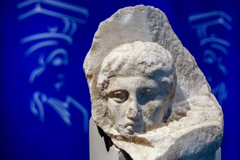 The marble head of a young man, a tiny fragment from the 2,500-year-old decoration of the Parthenon Temple on the ancient Acropolis, is displayed at the Acropolis Museum in Athens,(Thanassis Stavrakis/AP)