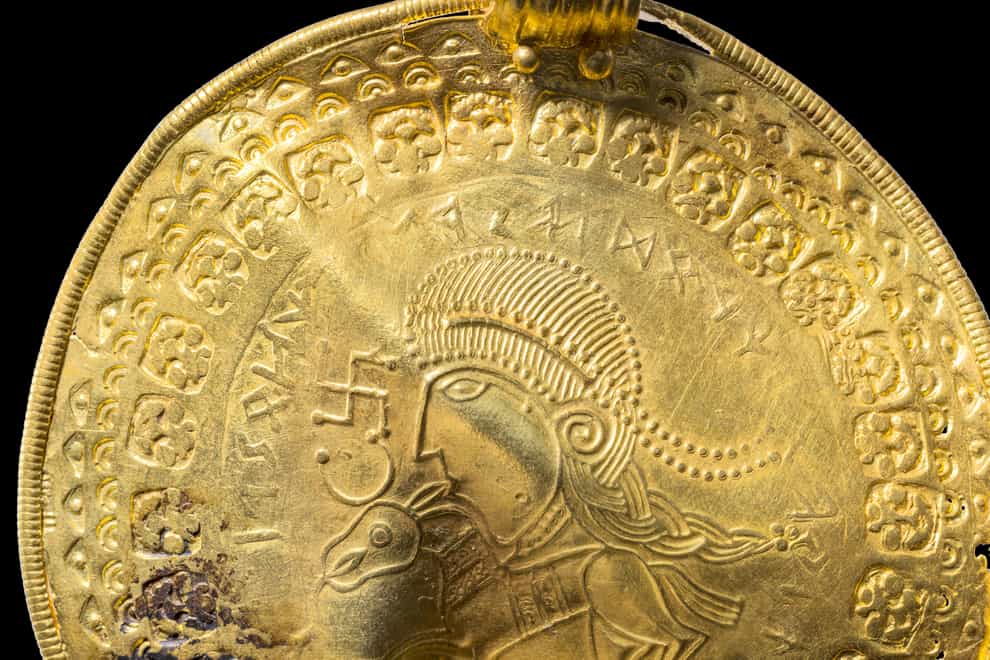 The inscription ‘He is Odin’s man’ is seen in a round half circle over the head of a figure on a golden bracteate unearthed in Vindelev, Denmark in late 2020 (The National Museum of Denmark/AP)