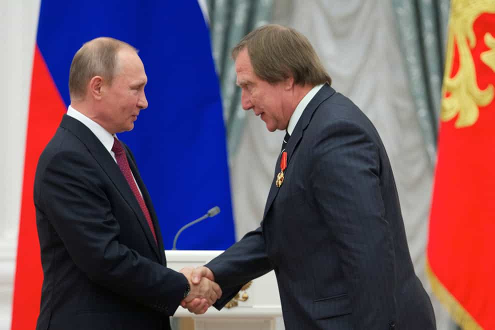 Russian President Vladimir Putin, left, presents a medal to Russian cellist Sergei Roldugin (Ivan Sekretarev, Pool/AP)