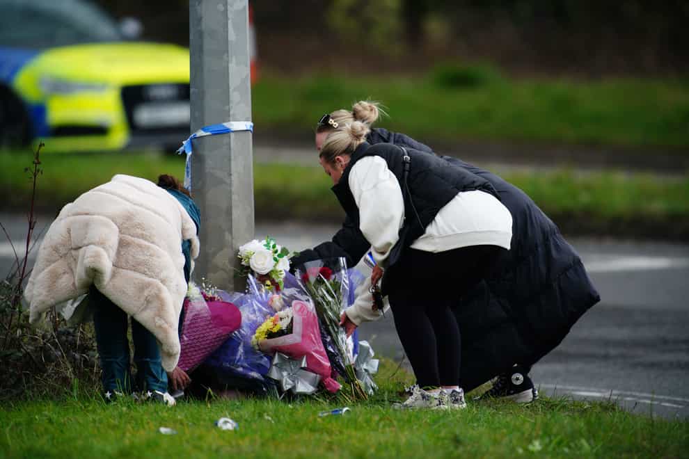 People lay floral tributes left near the scene in the St Mellons area of Cardiff (Ben Birchall/PA)