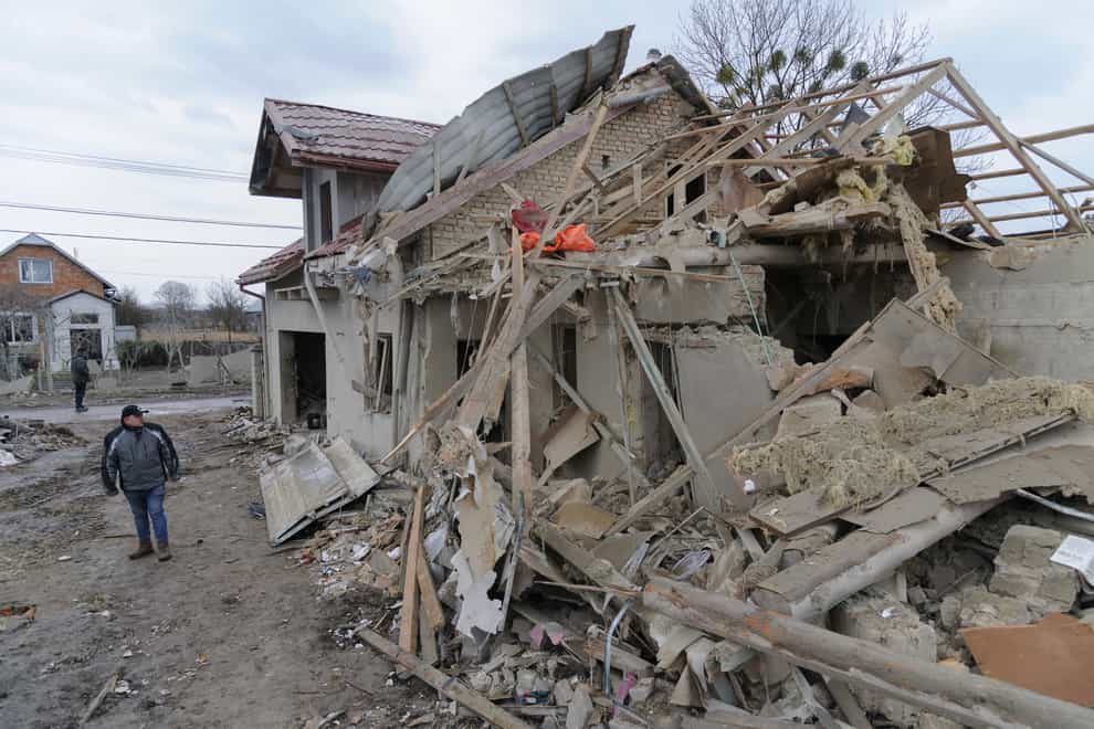 A villager passes by debris of private houses ruined in Russia’s night rocket attack in a village, in Zolochevsky district in the Lviv region (Mykola Tys/AP)