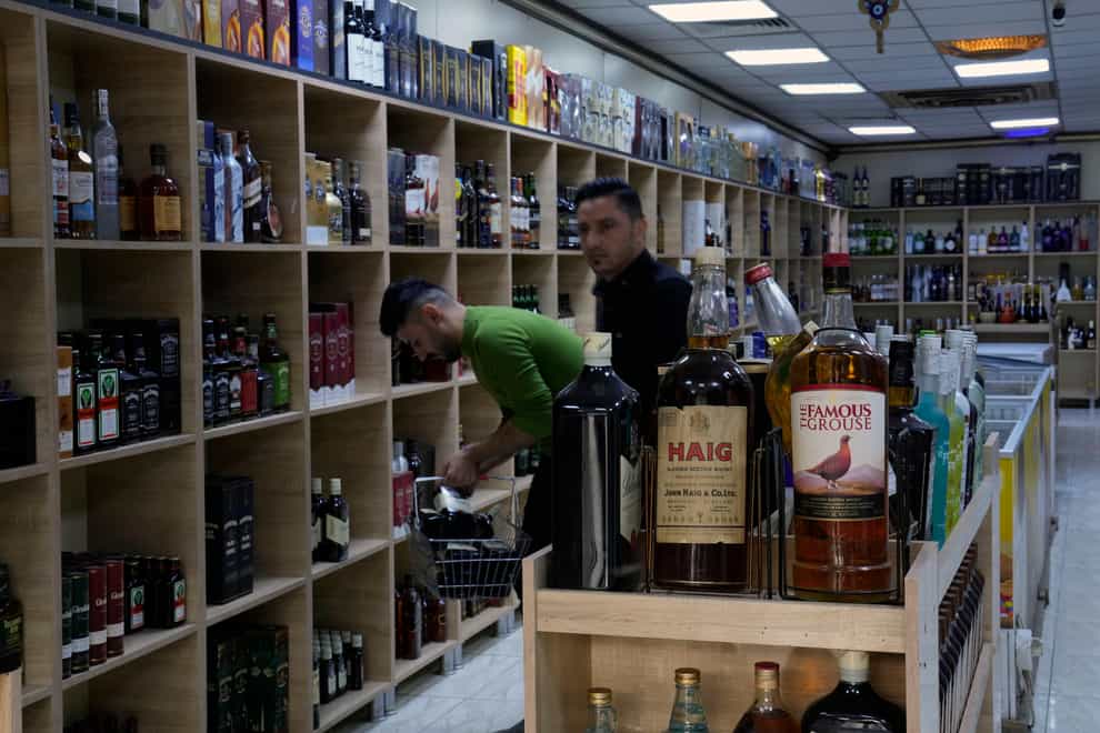 People buy alcohol in a booze shop in Baghdad (Hadi Mizban/AP)