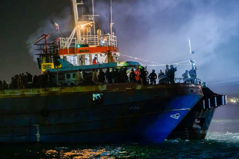 A fishing boat with some 500 migrants enters the southern Italian port of Crotone (AP)