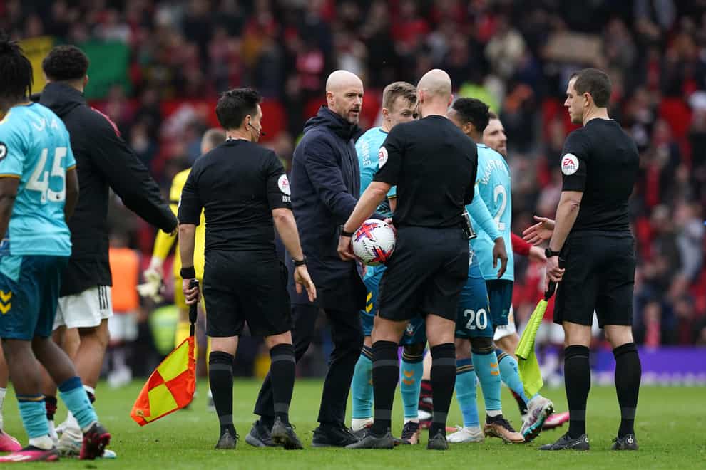Manchester United manager Erik ten Hag (centre) speaks to referee Anthony Taylor during the Premier League match at Old Trafford, Manchester. Picture date: Sunday March 12, 2023.