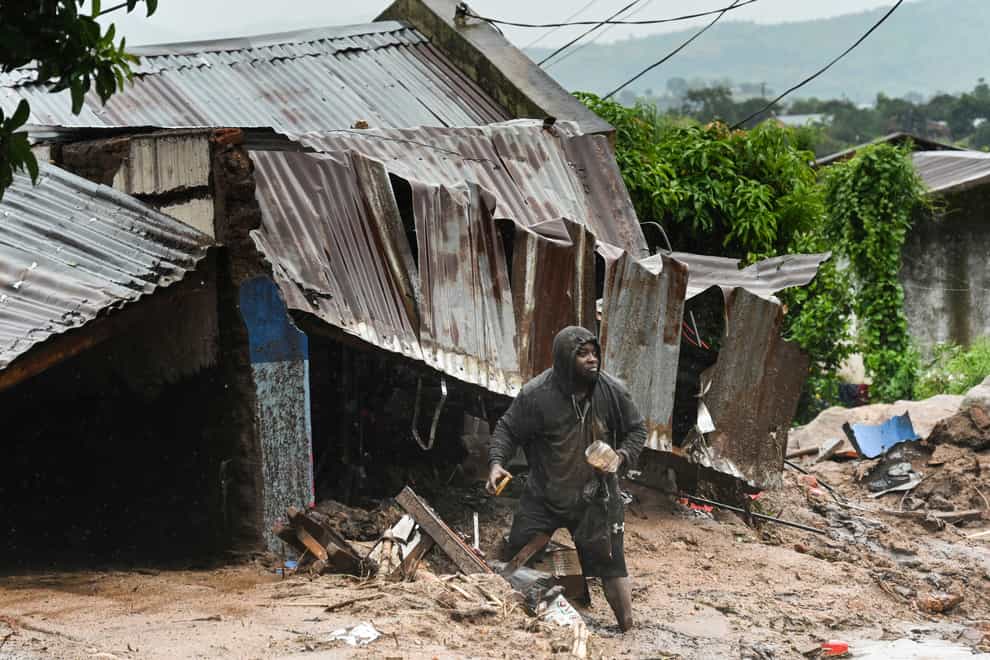 A man stands outside his damaged home in Blantyre, Malawi (Thoko Chikondi/AP)