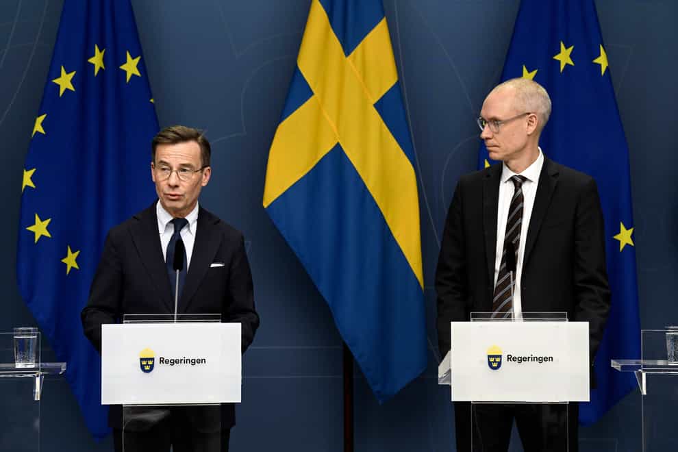 Sweden’s PM Ulf Kristersson, left, and Oscar Stenstroem, chief negotiator in the Nato process, hold a press briefing (Fredrik Sandberg/TT News Agency via AP)