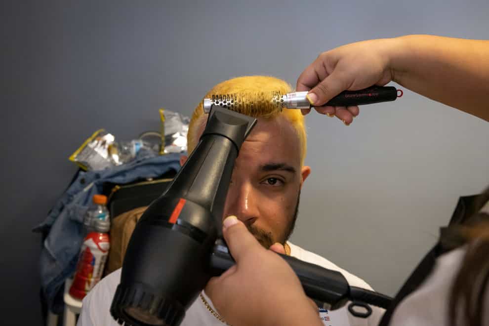 A fan of the Puerto Rico baseball team gets his hair dried after it was bleached (Alejandro Granadillo/AP)